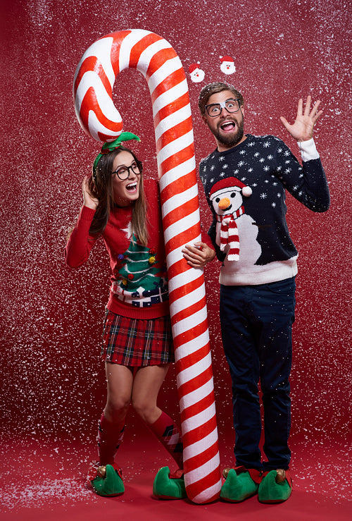 Couple standing with red and white christmas cane