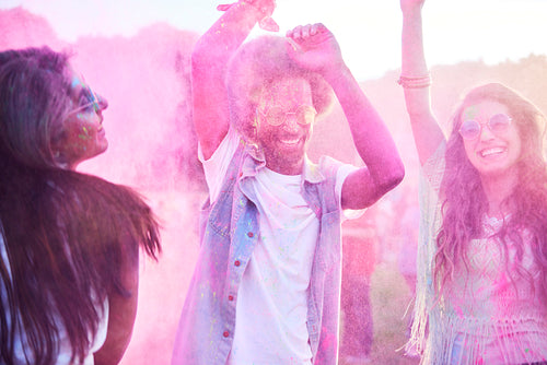 Colorful friends dancing in holi colors