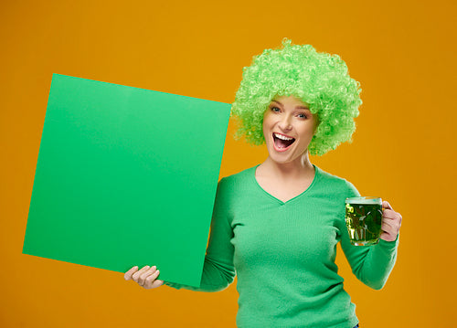 Portrait of excited woman with beer mug and blank banner
