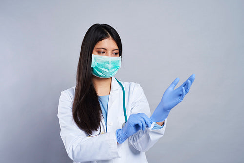 Female doctor wearing blue surgical gloves