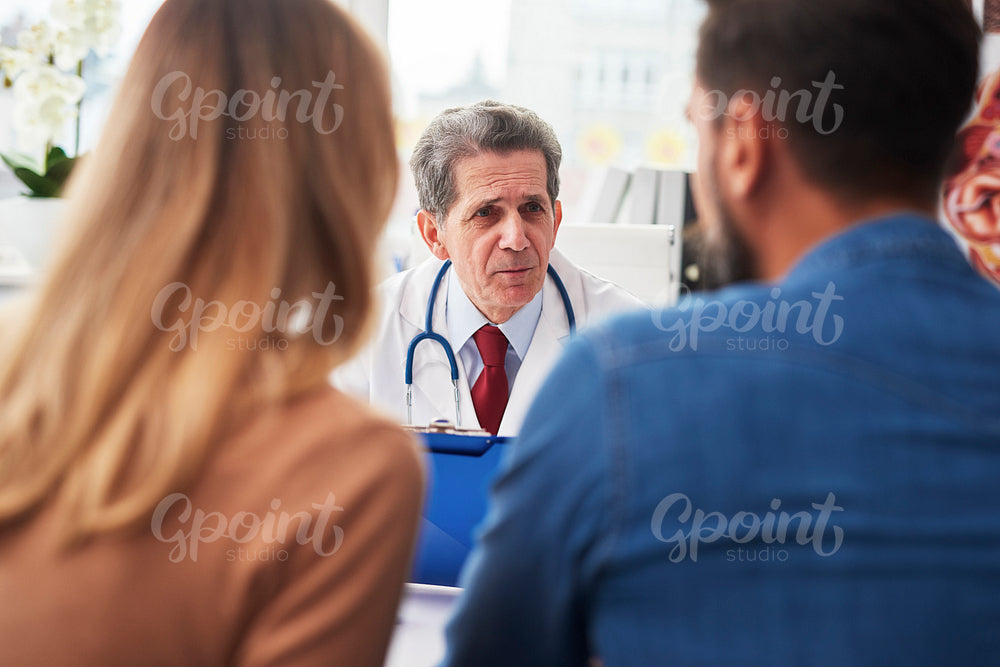 Young couple talking with gynecologist in doctor’s office