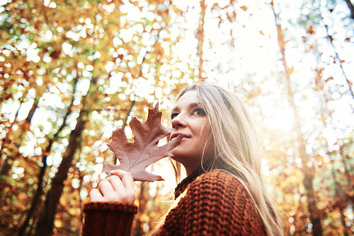 Beautiful  woman holding autumnal leaf