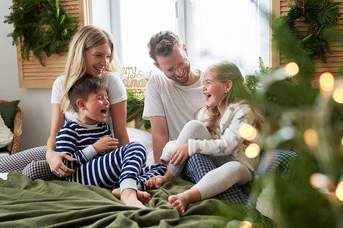 Family spending Christmas morning together in bed