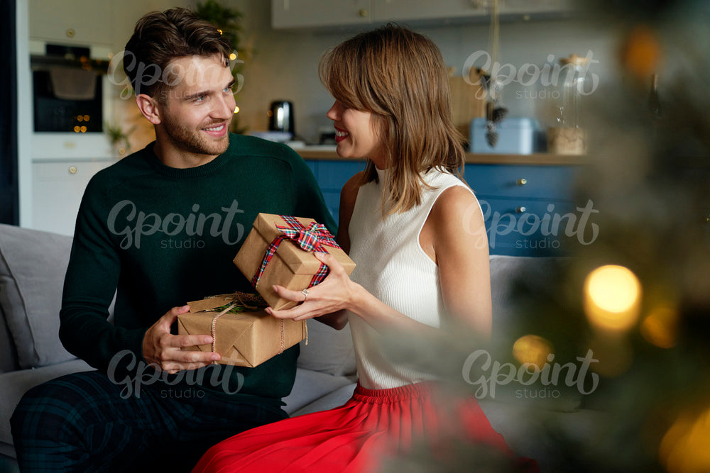 Couple exchanging gifts on Christmas time