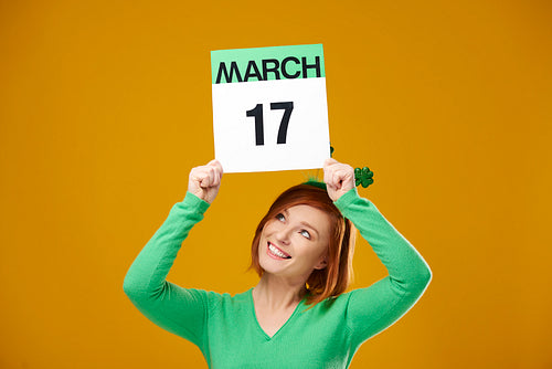 Woman showing calendar with a date for Saint Patrick's Day