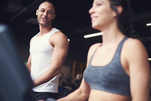 Young adult couple exercising on treadmill