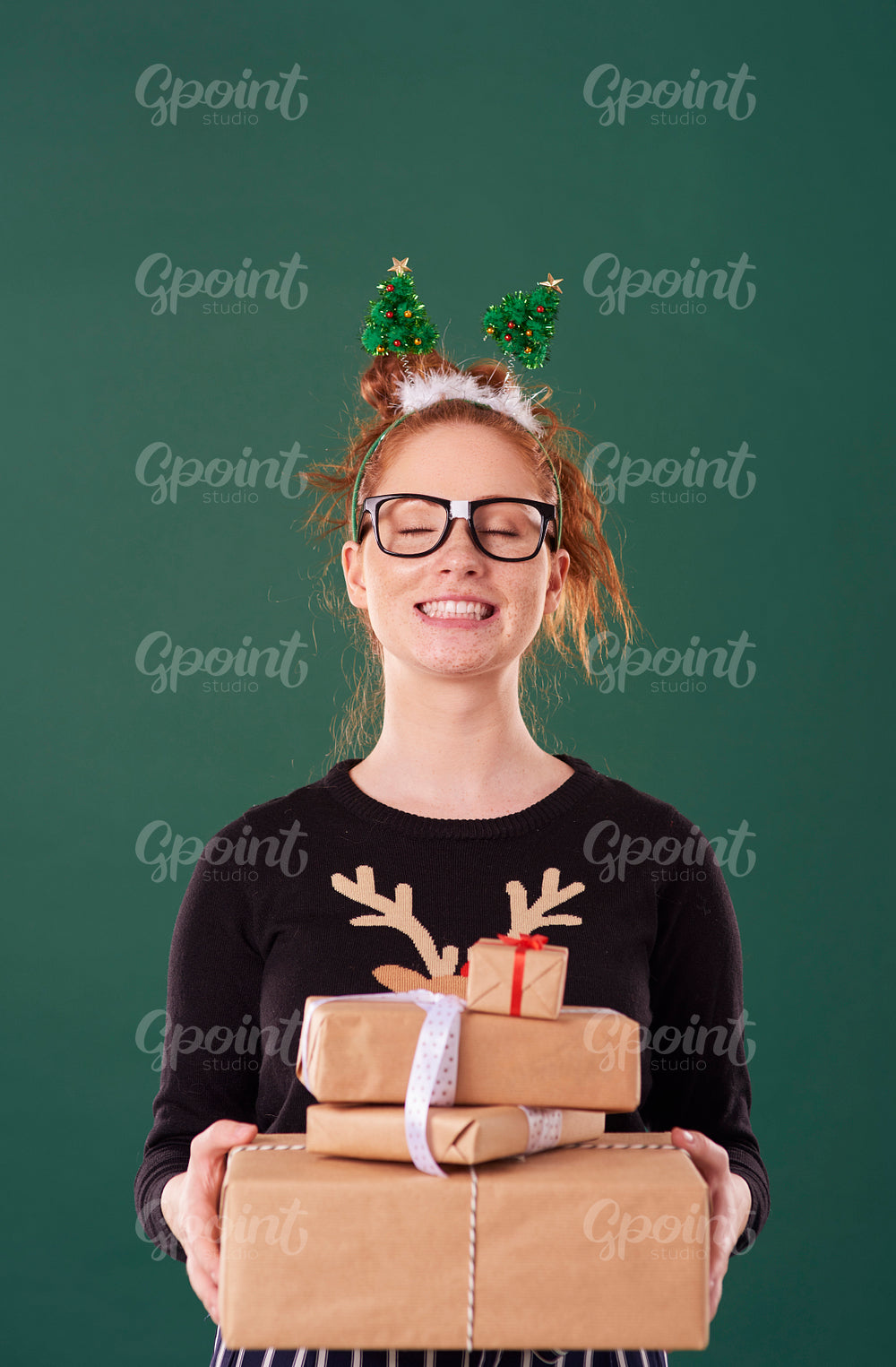 Happy girl holding stack of christmas present