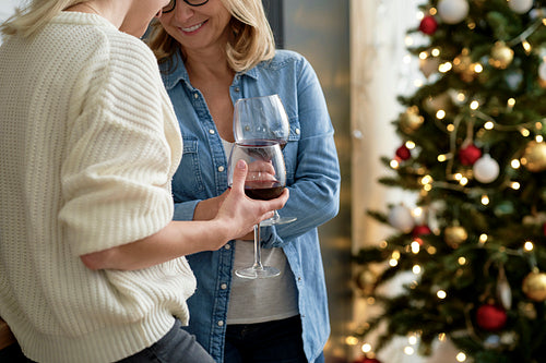 Close up of two women standing with glasses of wine