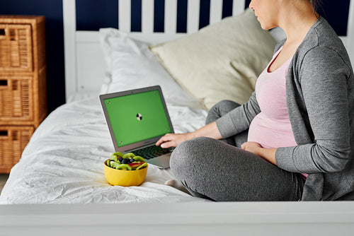 Pregnant woman spending time with computer