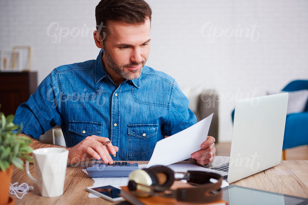 Businessman calculating his monthly expenses