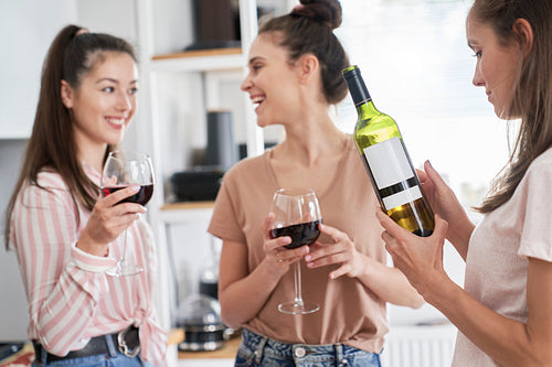 Three women drinking red wine at home