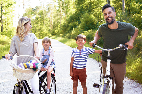 Portrait of happy family with bicycles in the forest