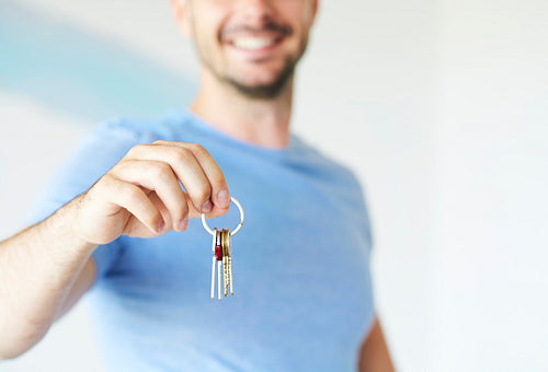 Man’s hand showing keys from new apartment
