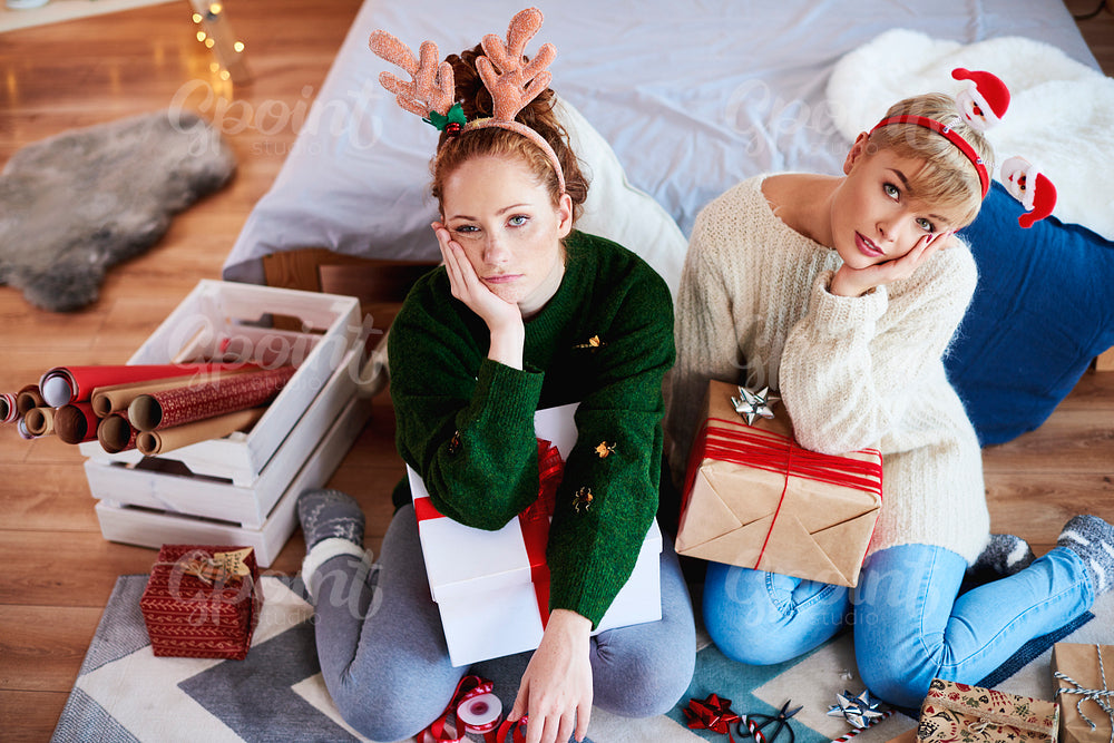 Two bored girls preparing christmas gifts for Christmas