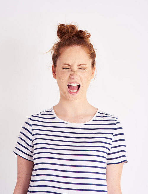 Portrait of woman with closed eyes shouting at studio shot