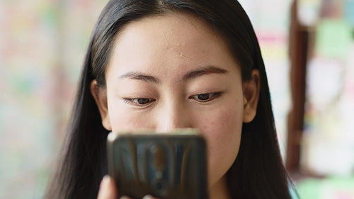 Handheld view of Vietnamese woman looking at smart phone