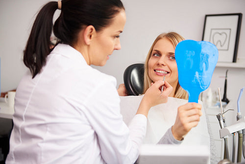 Stomatologist checking the woman's teeth during dental checkup