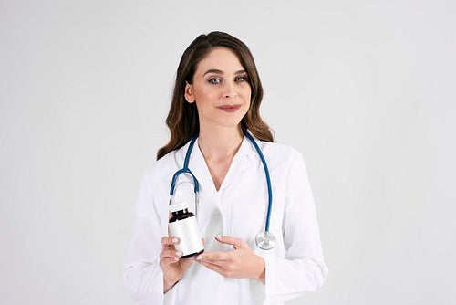 Portrait of smiling female doctor with stethoscope and medicament