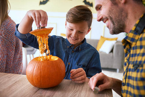 Boy carving pumpkins with father