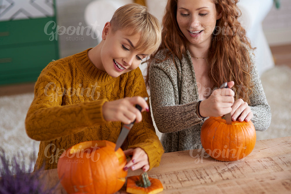 Friends carving pumpkins for Halloween