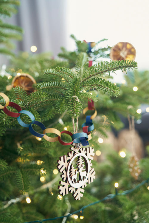 DIY paper chain and wooden pendant hanging on Christmas tree