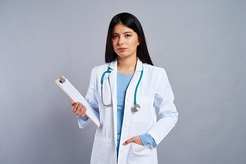 Female Asian doctor holding a clipboard with a document
