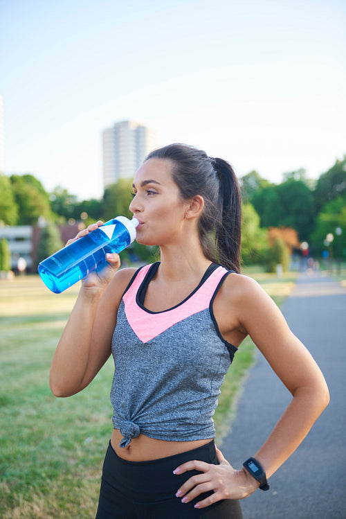 Young woman drinking water after hard workout