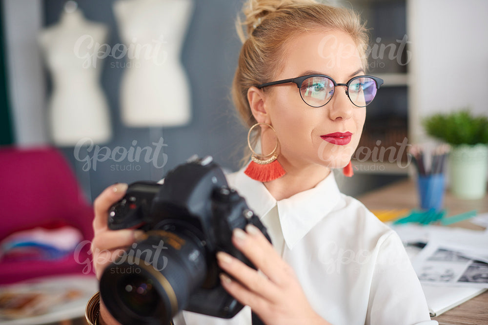 Thoughtful young woman holding camera