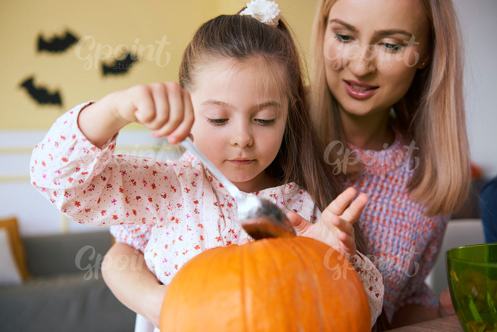Mother and daughter working on halloween pumpkins