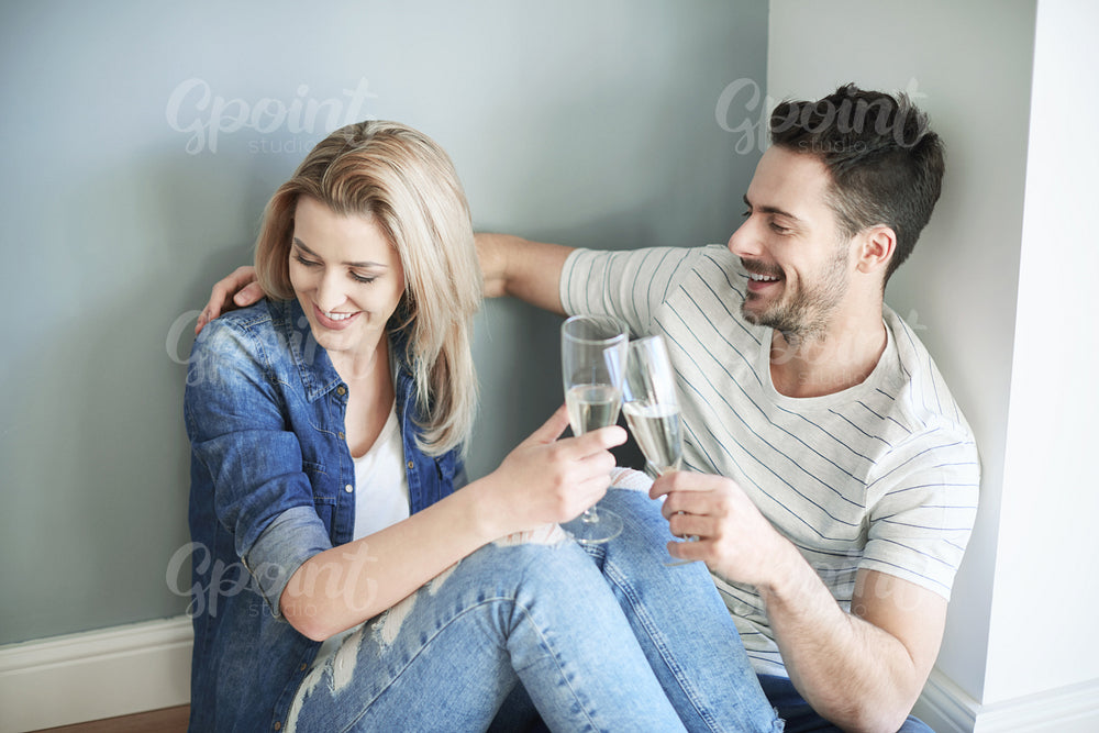 Couple sharing champagne whilst moving