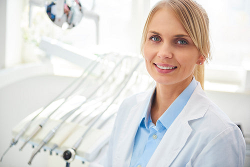 Portrait of smiling dentist in medical uniform in dentist's clinic