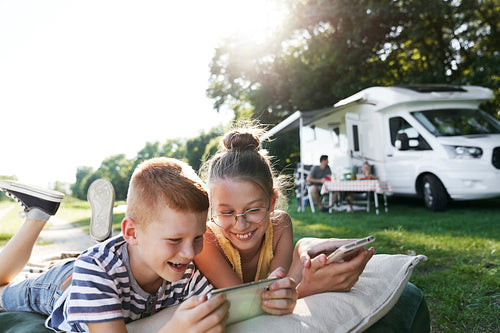 Children using mobile phones while being on camping
