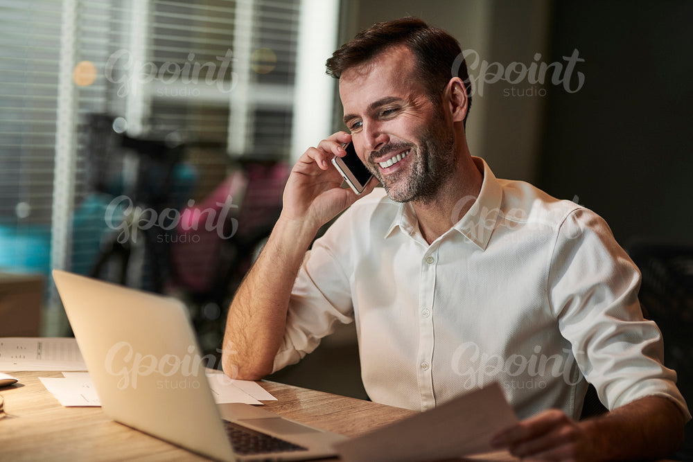Smiling businessman talking by mobile phone