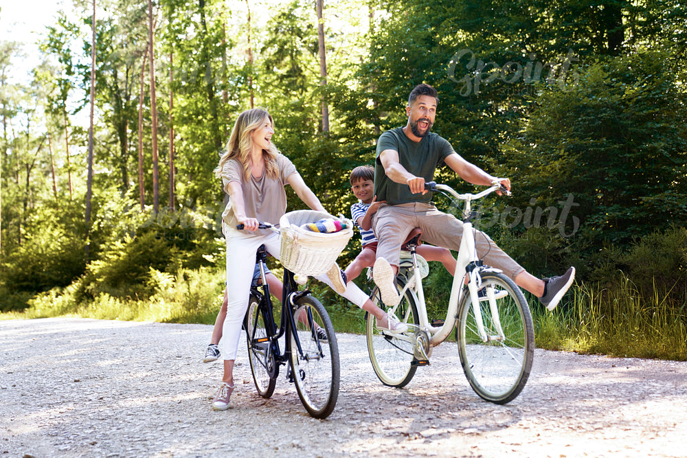 Playful family riding bikes in the woods