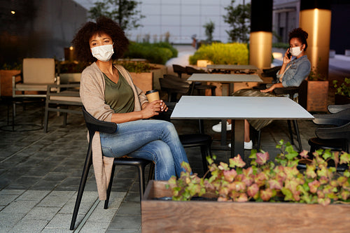 People in face mask sitting in a cafe