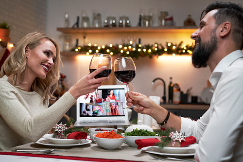 Happy couple make a Christmas toast on video call