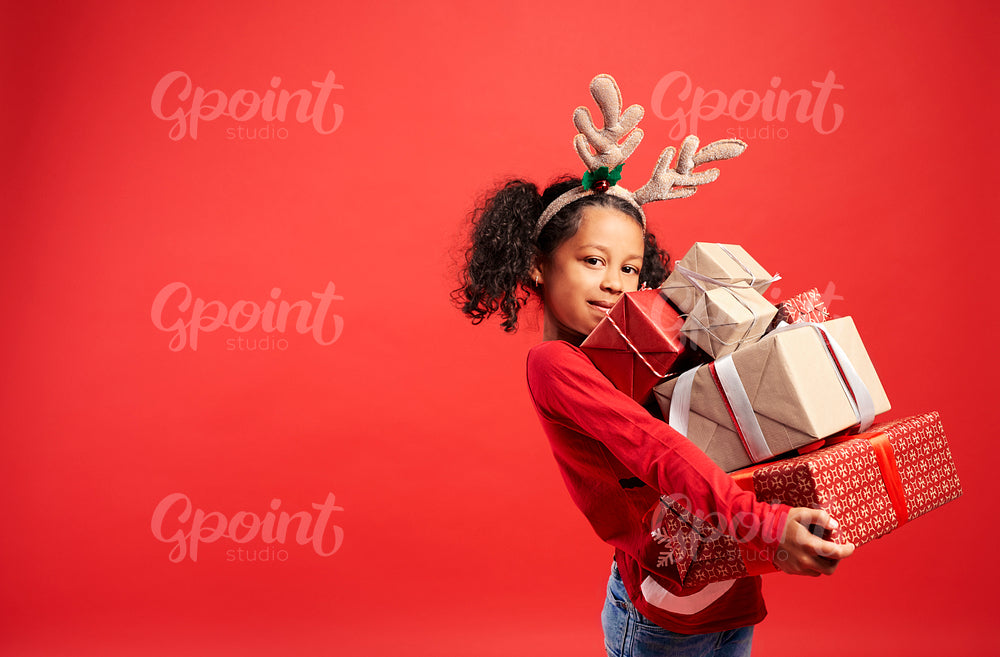 Portrait of African girl carrying stack of Christmas gifts