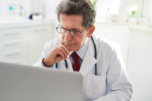 Senior doctor working with a laptop in doctor’s office