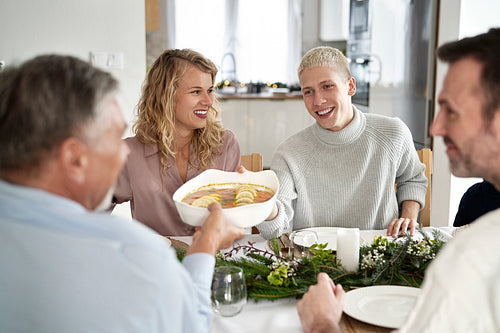 Caucasian family sharing food on Christmas Eve and being cheerful