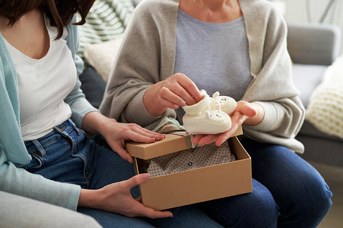 Woman giving gift box with knit baby booties