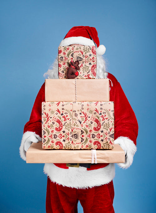 Santa Claus holding stack of christmas gifts