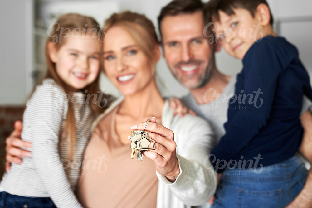 Close up of family holding key for a new apartment