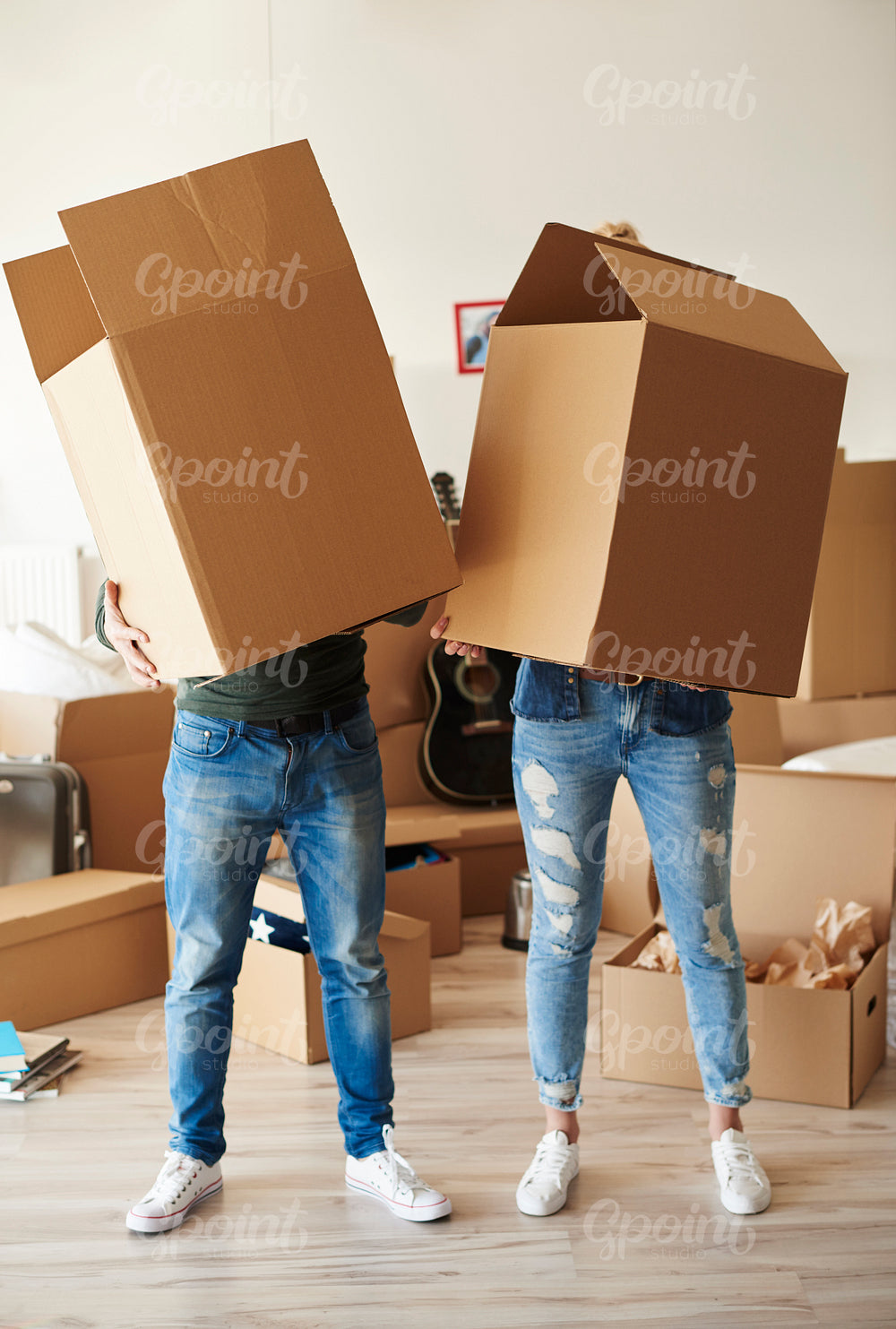 Couple faces behind cardboard boxes