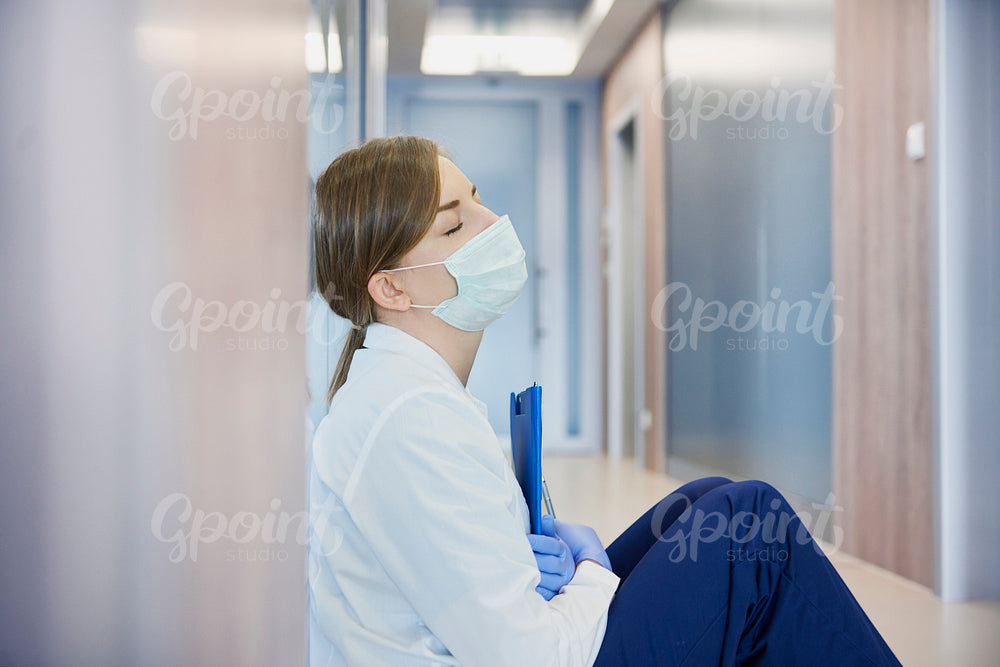 Exhausted doctor on hospital corridor