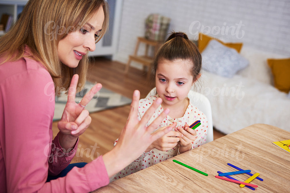 Young mum teaching child to count at home