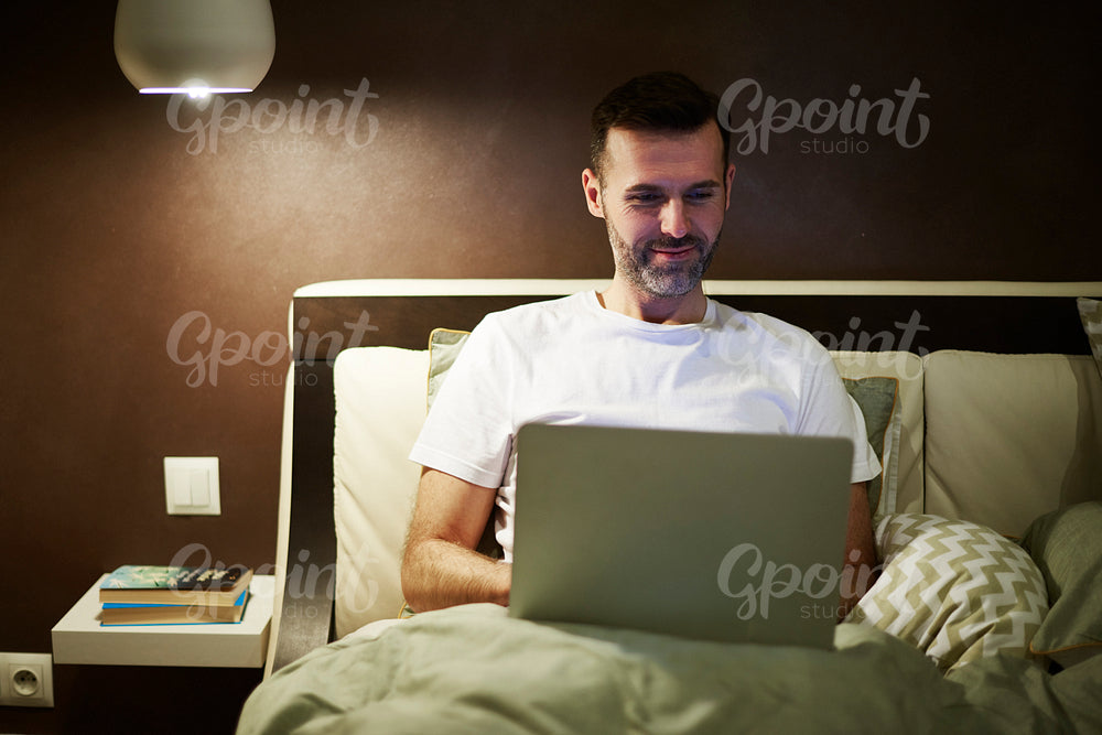 Mature man using a laptop at night