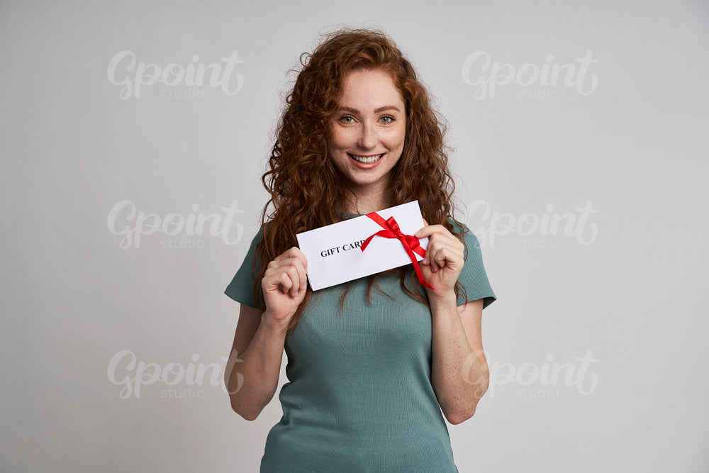 Happy woman holding gift card 