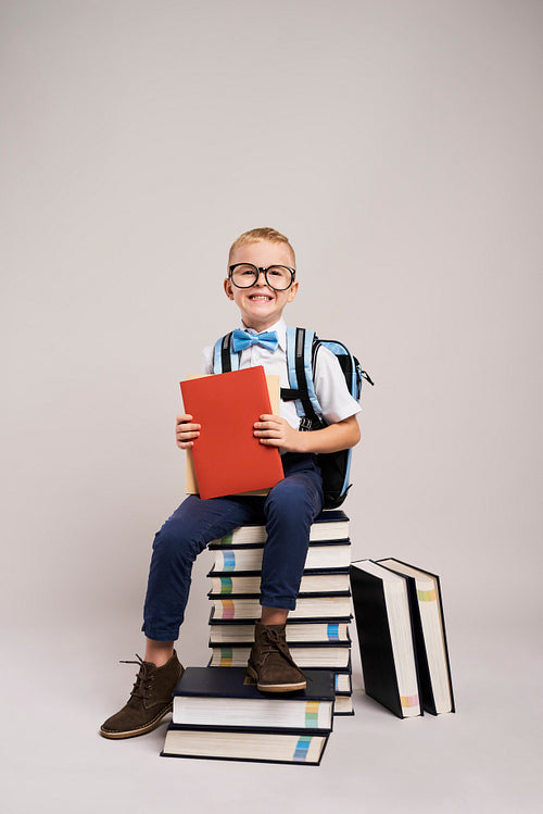 Portrait of smiling child among a stack of books