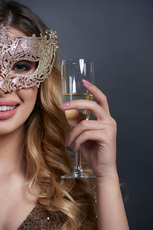 Part of woman with mask making a toast