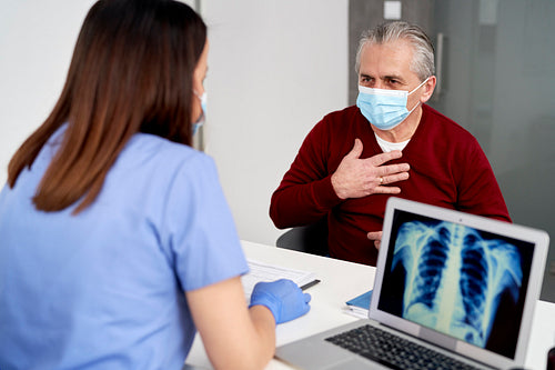 Female doctor analyzing the patient's lung X-rays during visit